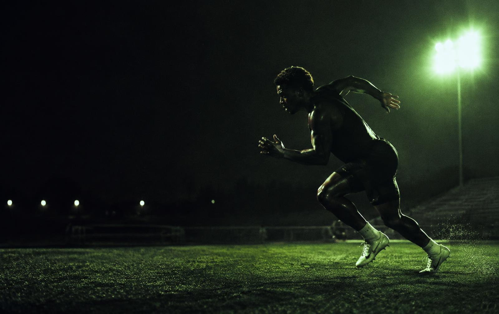 Athlete sprinting under stadium floodlights